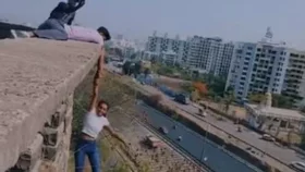 রিলস বানাতে ১০০ ফুট উঁচু ভবনে ঝুলছেন তরুণী!
