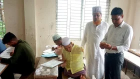 পা দিয়ে লিখে আলিম পরীক্ষা দিচ্ছেন রাসেল