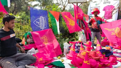 বিপিএল ফ্র্যাঞ্চাইজির পতাকা। পছন্দের ঝান্ডা নিয়ে দাঁড়িয়ে আছেন একজন। পাশে আবার ফিলিস্তিনের পতাকাও।