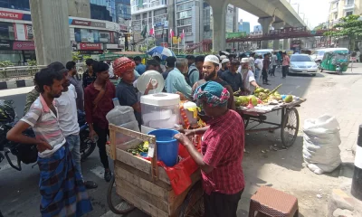 বাংলামোটর মোড়ে দাঁড়িয়ে শরবত জন্য অপেক্ষা করছে কয়েকজন। ছবি: দেশ রূপান্তর