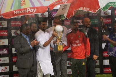 ছাতার নিচে দাঁড়িয়েই টাইগার অধিনায়ক লিটন দাসের হাতে শিরোপা তুলে দেন ক্রীড়া উপদেষ্টা আসিফ মাহমুদ সজীব ভূঁইয়া।