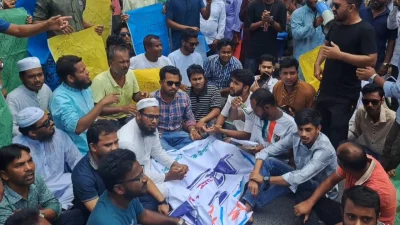মানববন্ধন শেষে অন্দোলনকারীরা সড়কে বসে পড়ে বিক্ষোভ করে। ছবি: প্রতিনিধি  