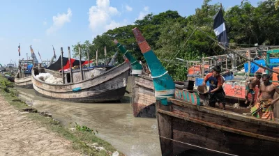 নৌকার পরিষ্কারে ব্যস্ত এক জেলে। ছবি: দেশ রূপান্তর 